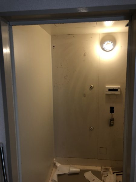 ダイノックシートを浴室の壁に貼っている様子